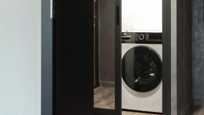 A modern laundry room with a front-loading washing machine and a dryer. - Apartment 8 (Lovech)