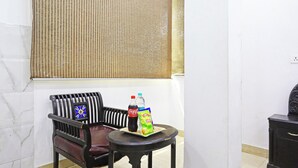 Una habitación con una silla, una mesita, una botella de Coca-Cola y un paquete de snack.