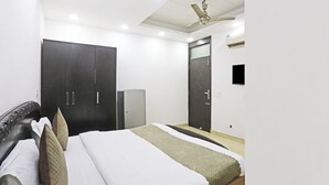 Un dormitorio con cama, armario, espejo, ventilador de techo e iluminación empotrada.