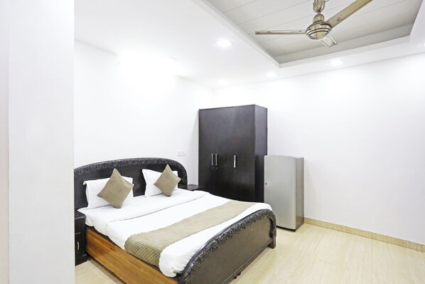 Un dormitorio con cama, armario y ventilador de techo.