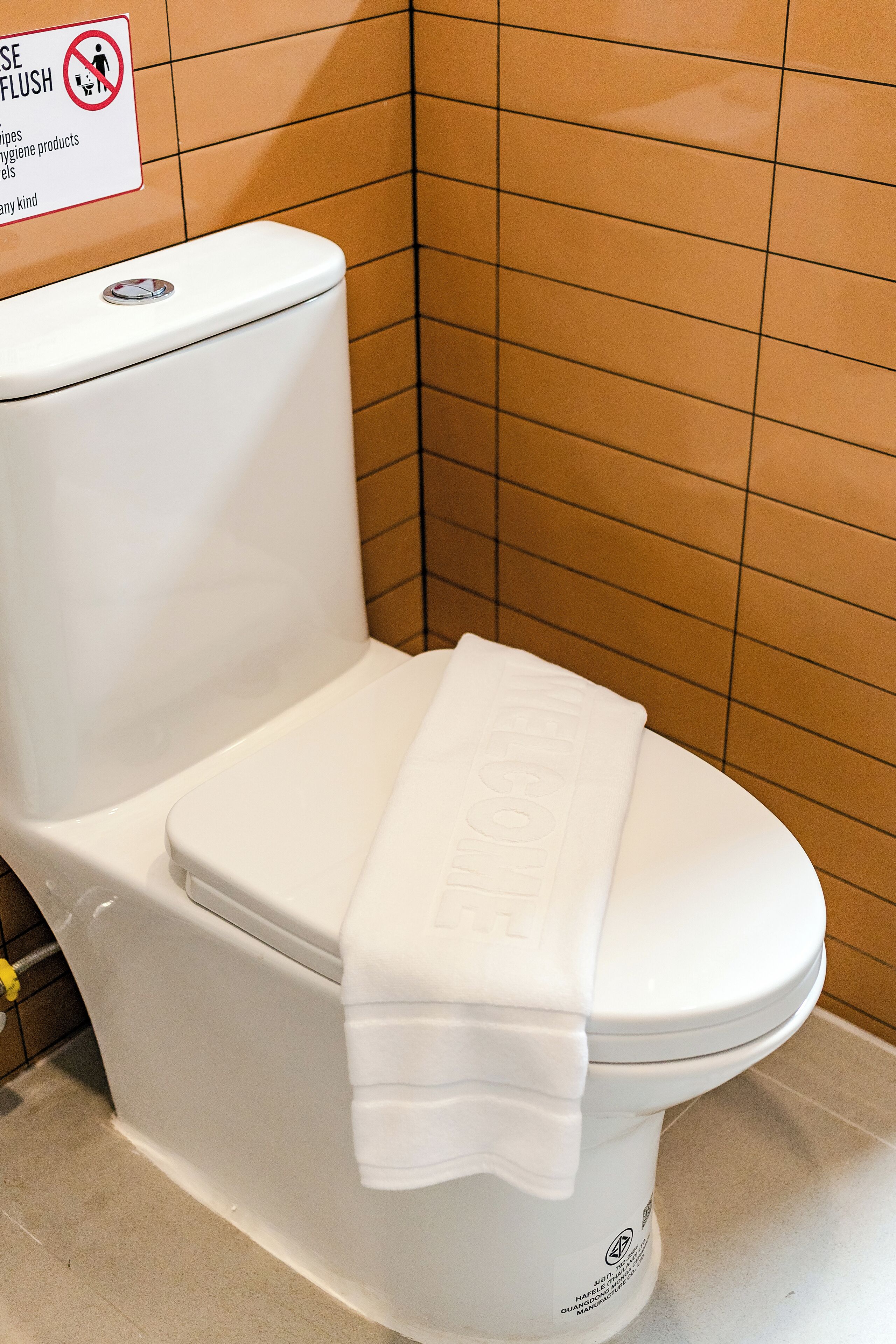 A white toilet with a white tissue box on top.