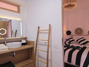 A bathroom with a wooden vanity, a white sink, and a mirror with a ring light. - Taghazout Ait Bihi Cosy short-term accommodation (Ait Bihi)