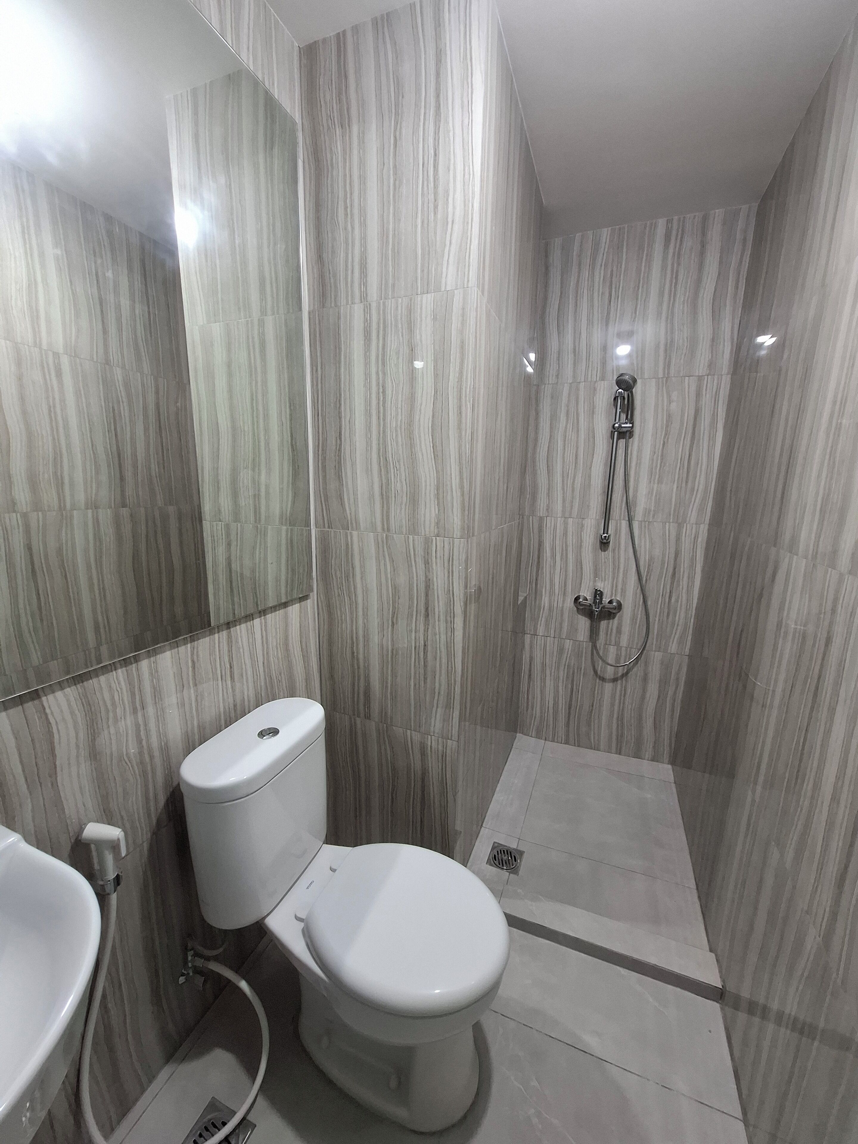 Un baño moderno con inodoro, lavabo y ducha.