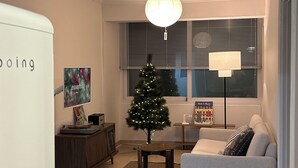 Un salon avec un sapin de Noël, un canapé, une table basse et une lampe.