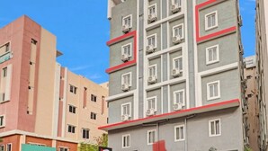 A multi-story building with a modern architectural design, featuring a series of balconies and air conditioning units. - White Ridge Hotel-Kphb (Hyderabad)
