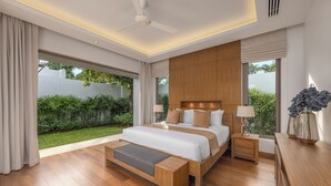Une chambre moderne avec un grand lit, un plancher en bois, un ventilateur de plafond et une vue sur un jardin.