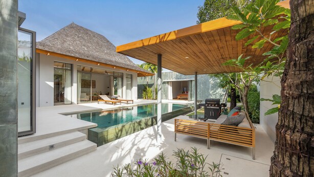 Une maison moderne dotée d’une piscine, d’un espace salon extérieur et d’un patio couvert.