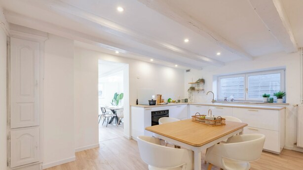 A modern kitchen with white cabinetry, a wooden dining table, and white chairs. - La Maison «  Schmoutz 💋 »     Elegant Alsatian house dating from 1752 (Forstheim)