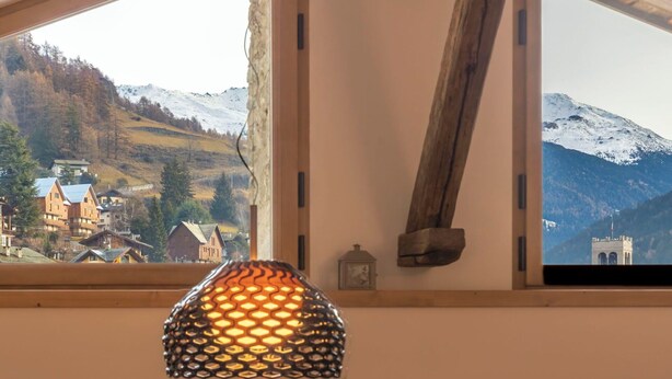 A room with a window overlooking a mountainous landscape, a wooden beam, and a hanging lamp. - Beautiful apartment for 5 people with WIFI and TV (Bormio)