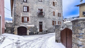 A stone building with a wooden door and windows, surrounded by snow. - Beautiful apartment for 5 people with WIFI and TV (Bormio)