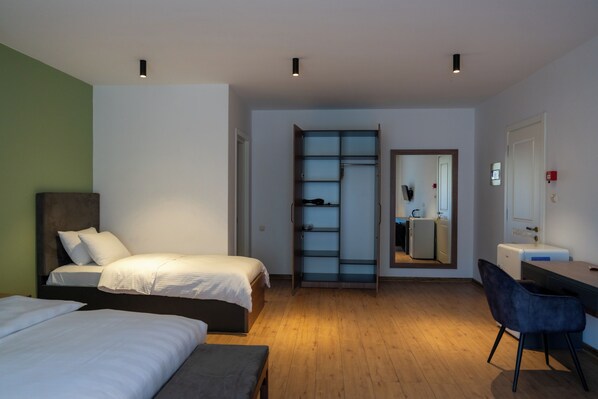 A modern hotel room with two beds, a desk, a chair, and a wardrobe. - Machakhela Inn - Winery and Resort (Khelvachauri)