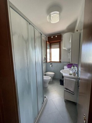 A bathroom with a toilet, bidet, sink, and a towel rack. - Spacious Apartment With Pool Access (San Michele al Tagliamento)