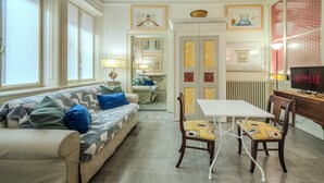 A living room with a sofa, chairs, a table, and a TV. - Absolute Center, Parking - (Private Museum) (Mantova)