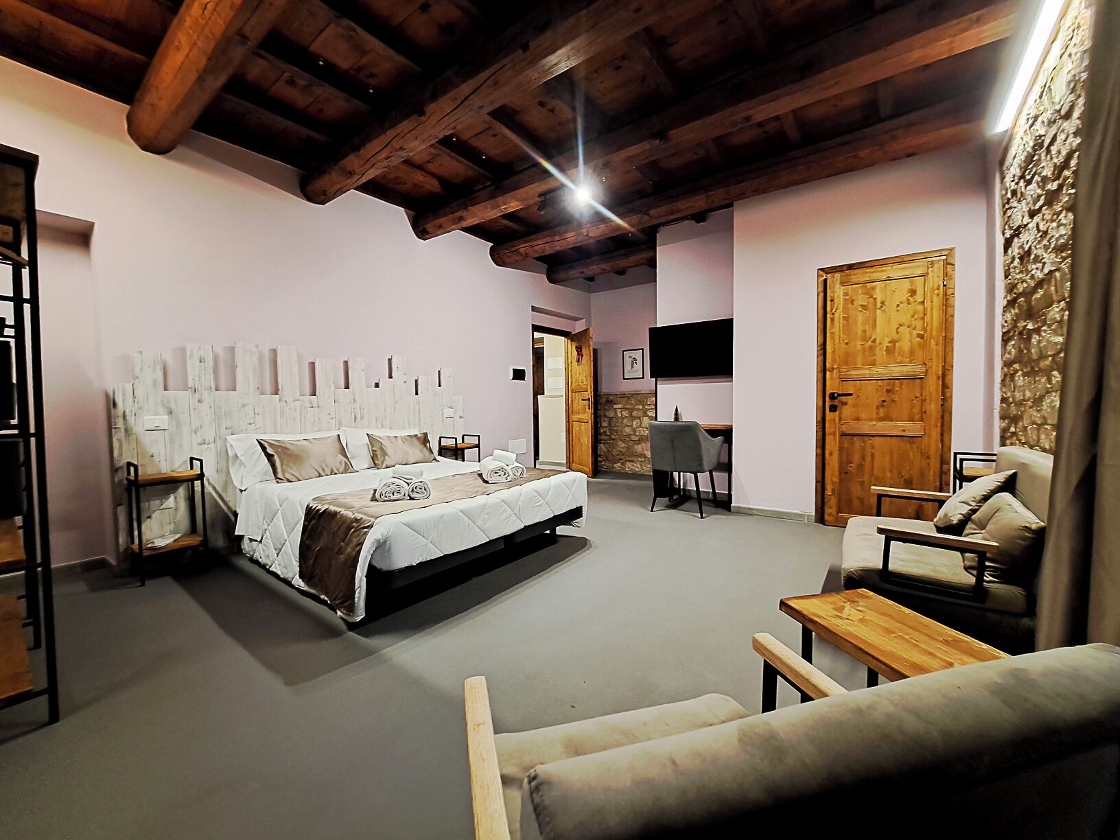 Une chambre spacieuse avec un grand lit, un bureau et une chaise.