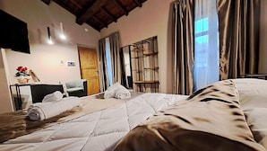 Une chambre d’hôtel avec un lit, une chaise, un bureau et une fenêtre avec des rideaux.