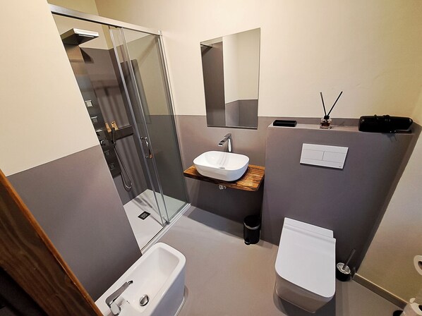 A modern bathroom with a glass shower enclosure, a white sink, a toilet, and a mirror. - IL MOLINO DEL SIGNORE (Pergola)