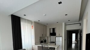 Un soggiorno moderno con un divano grigio, un tavolino rotondo in legno e un tappeto bianco.