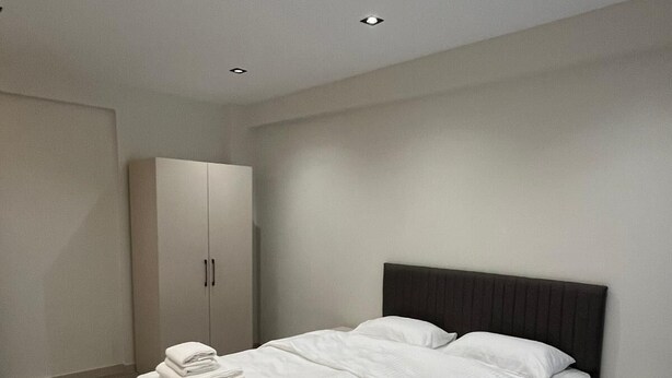 Una camera da letto moderna con un letto grande, un armadio e illuminazione integrata.