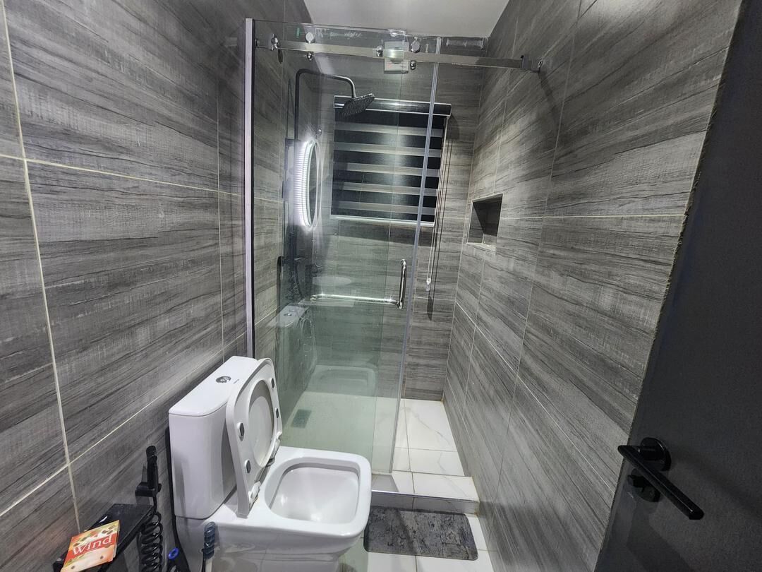 Une salle de bain moderne dotée d’une douche à parois de verre, de toilettes et d’un bidet.