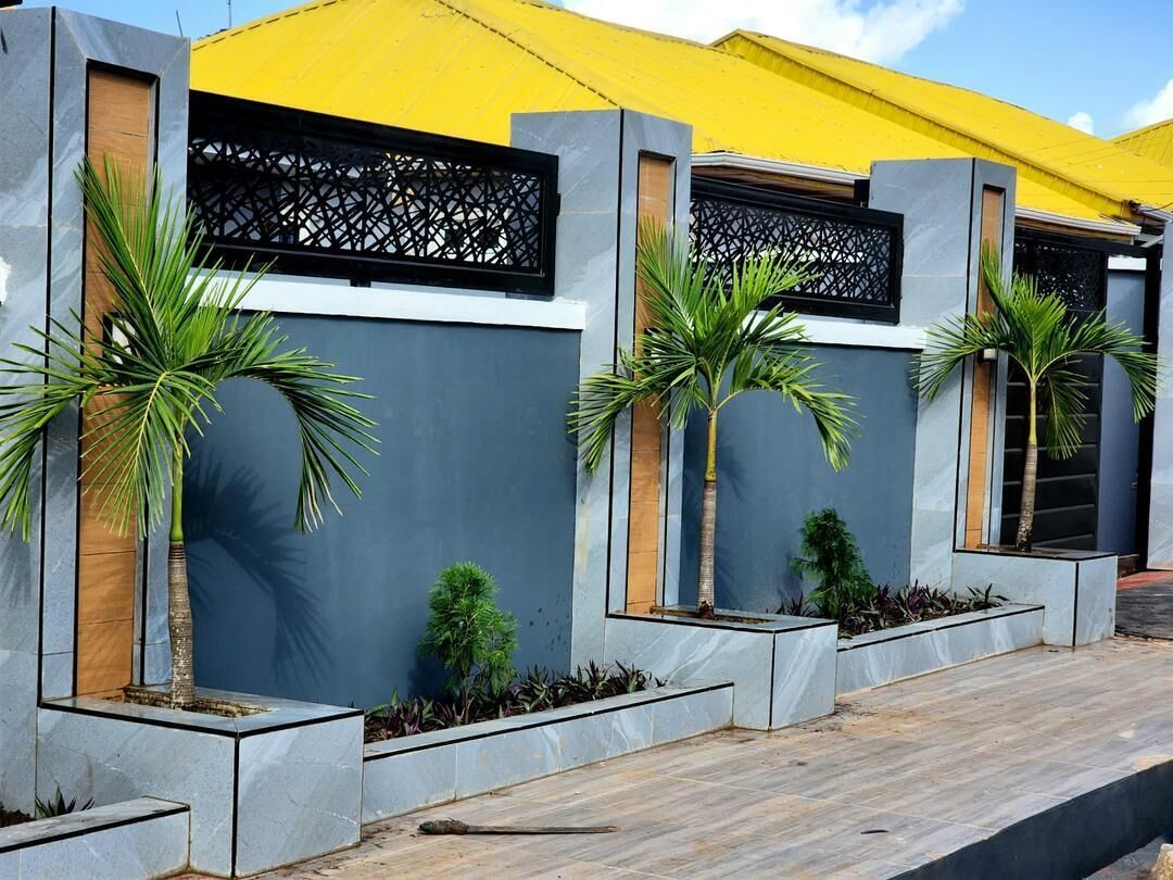 A modern building with a yellow roof, grey walls, and black decorative panels.