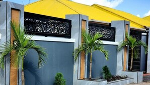 Un edificio moderno con techo amarillo, paredes grises y paneles decorativos negros.