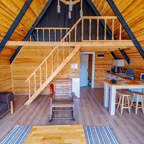 A wooden interior with a loft bedroom, a kitchen area, and a staircase. - Bugi Suit Bungalov (Atakum)