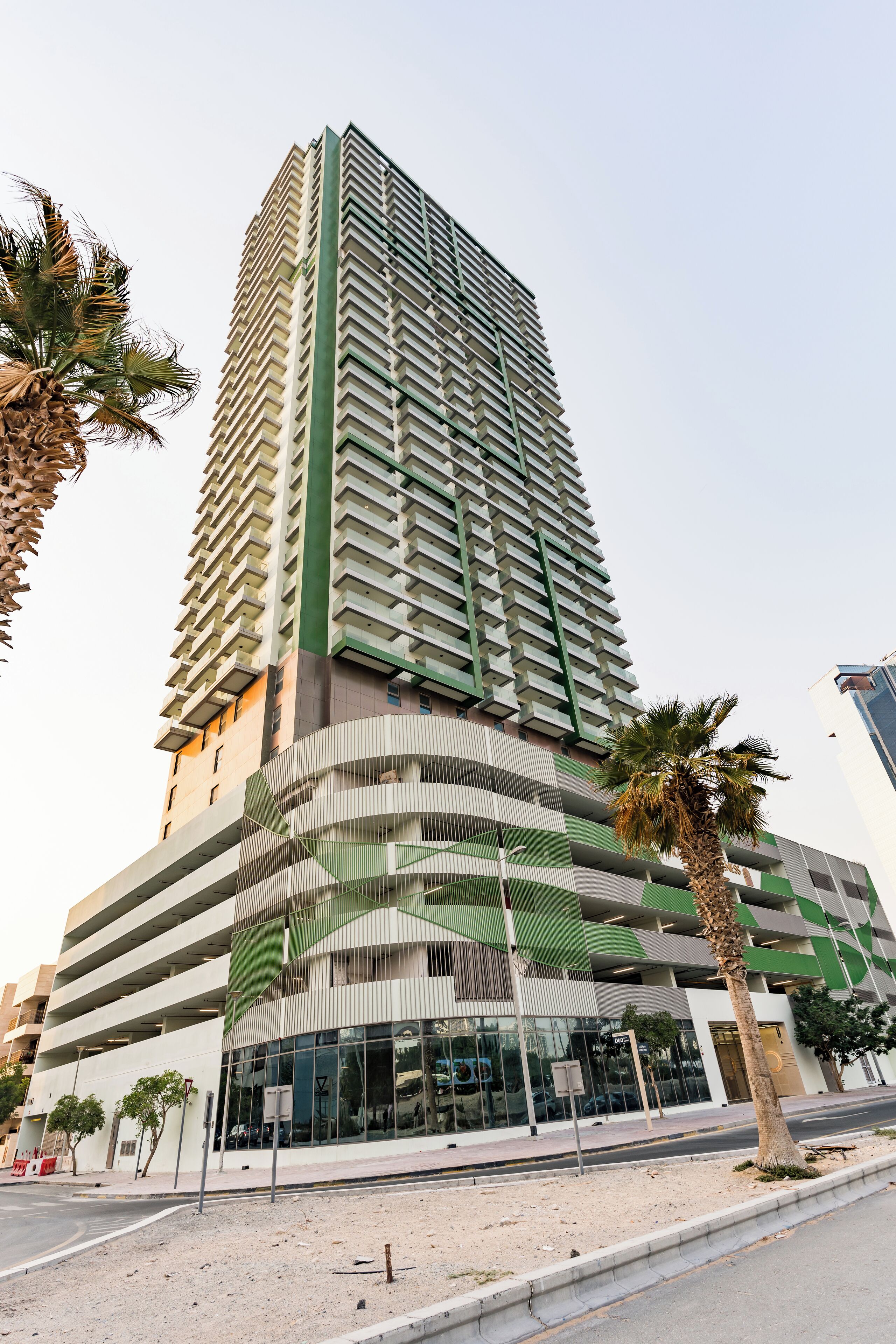 A high-rise building with a modern design, featuring multiple balconies and a mix of glass and concrete facades.