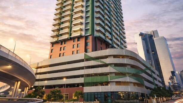 A modern high-rise building with a curved facade and multiple balconies. - Tranquil Wellness Hotel Apartments (Dubai)