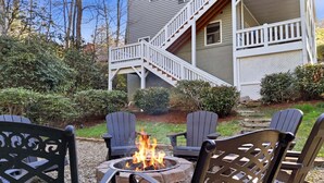 A fire pit with chairs, a staircase, and a house with a porch. - Forget-Me-Not: Spacious 6-Bedroom Retreat, Walk to Downtown (Highlands)