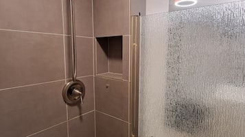 Een douche, handdoeken, zeep, shampoo