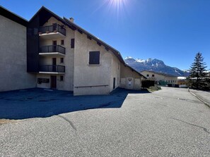 A building with a balcony, a mountain in the background, and a clear sky. - 3-room apartment with garden and parking, Briançon (Briançon)