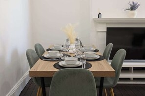 A dining table set with plates, glasses, and a vase of dried flowers. - Charming 3BR GlebeTerrace w Courtyard & BBQ (Glebe)