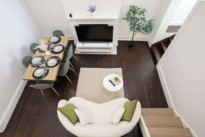 A dining area with a TV, a sofa, and a staircase. - Charming 3BR GlebeTerrace w Courtyard & BBQ (Glebe)