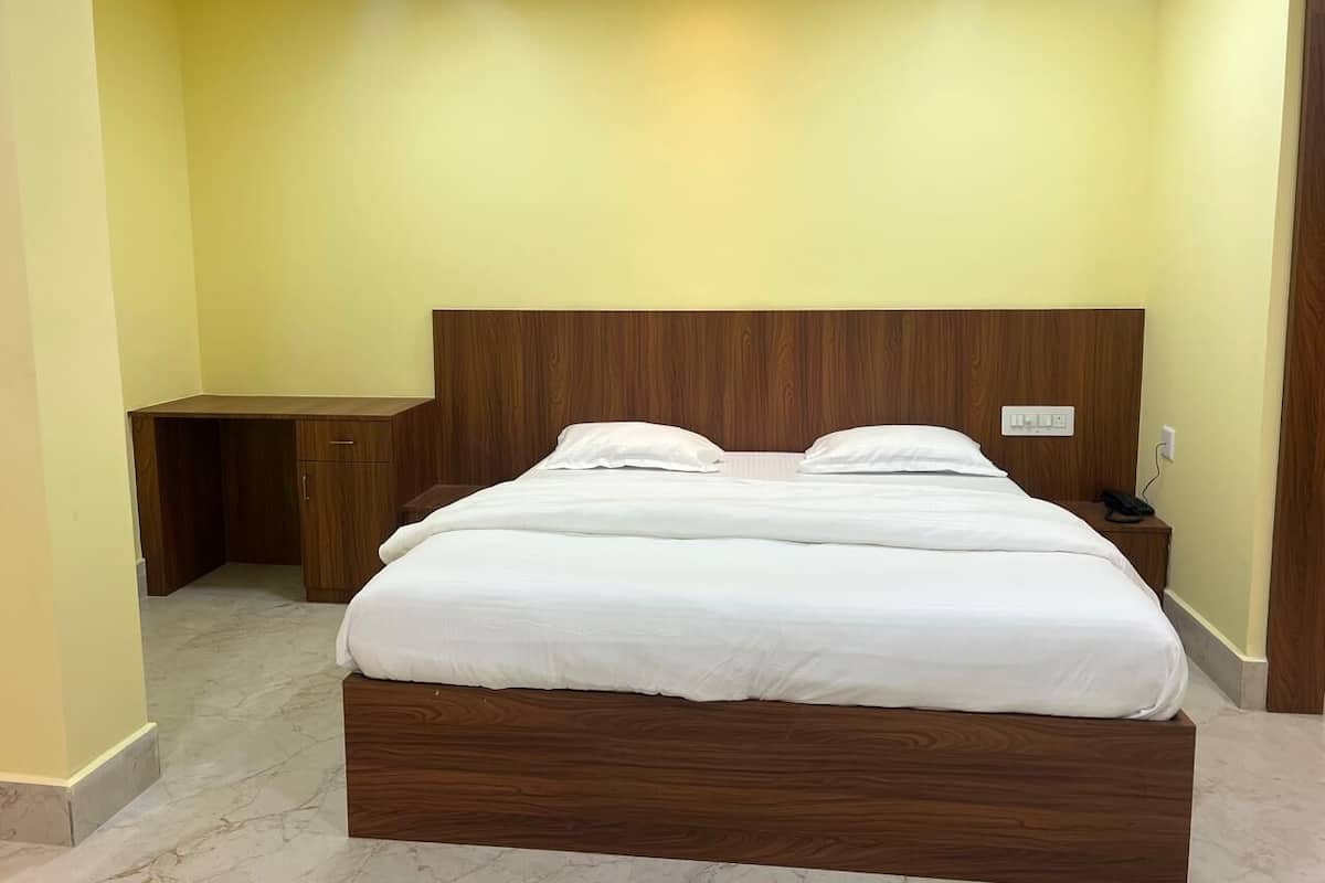 Une chambre à coucher avec un lit en bois, un bureau et une table de chevet.