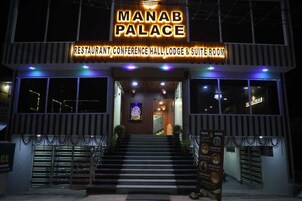 Exterior del Palacio Manab, con un letrero destacado que indica que es restaurante, salón de conferencias, hospedaje y dispone de habitaciones tipo suite.