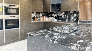 A modern kitchen with a marble countertop, built-in ovens, and pendant lighting. - Elegant family home, 2x jacuzzi corner baths, Contract Workers and NHS Welcome. (Luton)