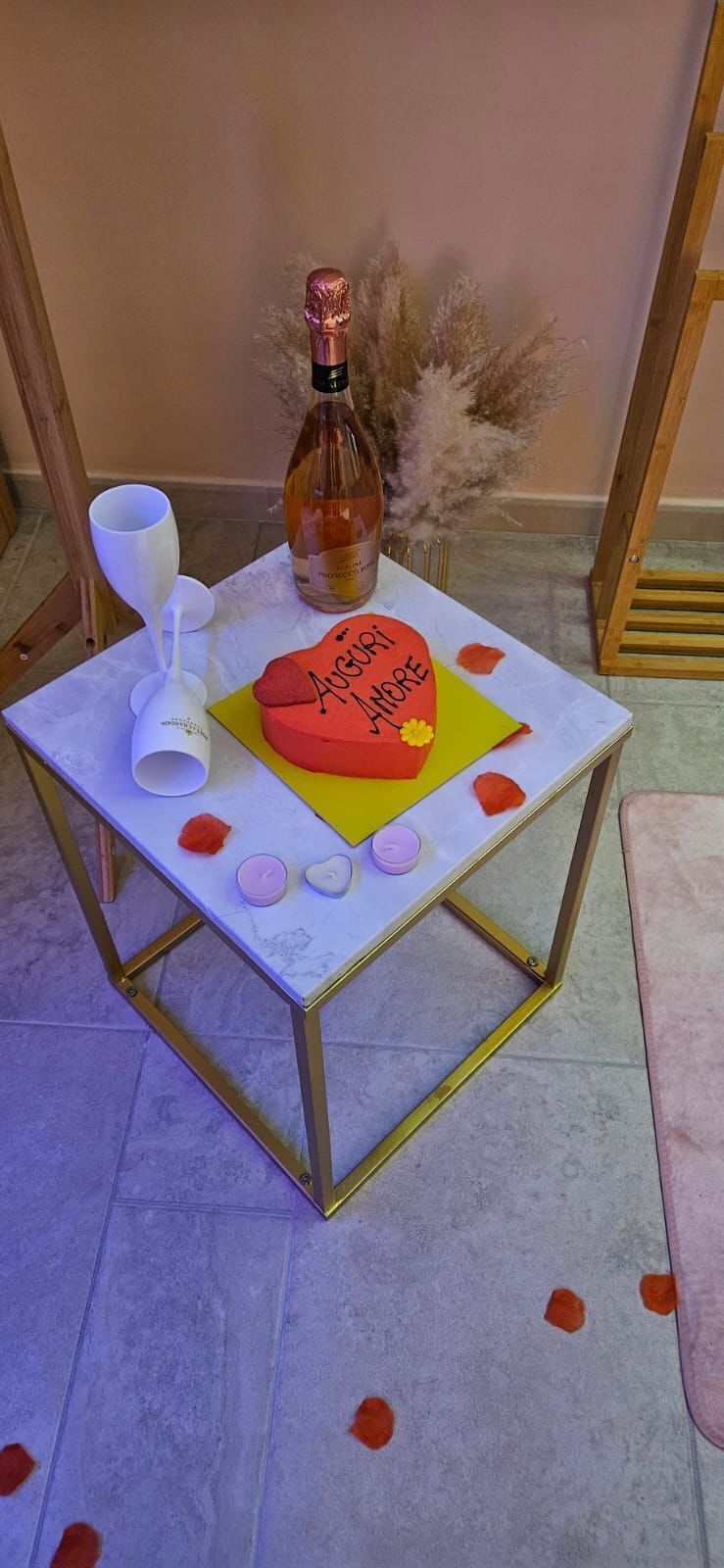 A small table with a decorative cake, a bottle, and a candle.