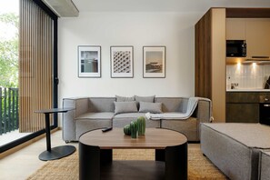 A modern living room with a grey sofa, a round coffee table, and three framed pictures on the wall. - w Sophisticated 3BR in the Heart of San Rafael (Mexico City)