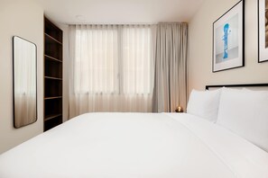 A hotel room with a large bed, a wardrobe, a window with curtains, and a framed picture on the wall. - w Sophisticated 3BR in the Heart of San Rafael (Mexico City)