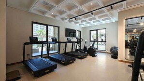 A gym with treadmills, exercise bikes, and a large mirror. - Stayshort - Bright 1 Bedroom in Madinat Jumeirah Lving That Sleeps 2 (Dubai)