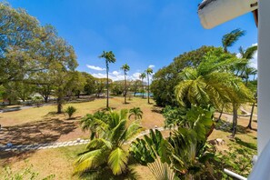 A view of a landscaped area with palm trees and a clear blue sky. - Glitter Bay Estate 414 1 Bedroom Apts (Holetown)