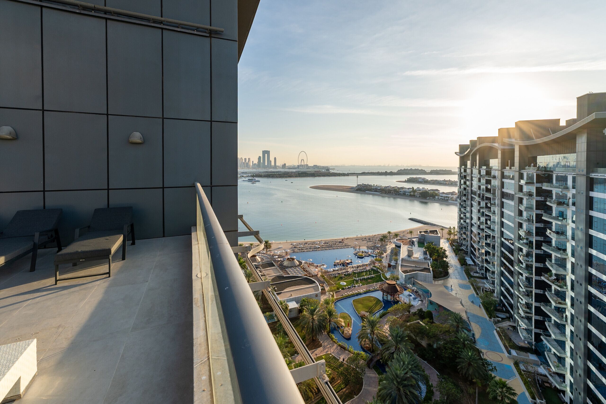 Een hoog hotel met balkon, uitzicht op een jachthaven en de stadshemel.