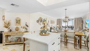 Un área de estar amplia con una mesa de comedor, sillas y una isla de cocina.