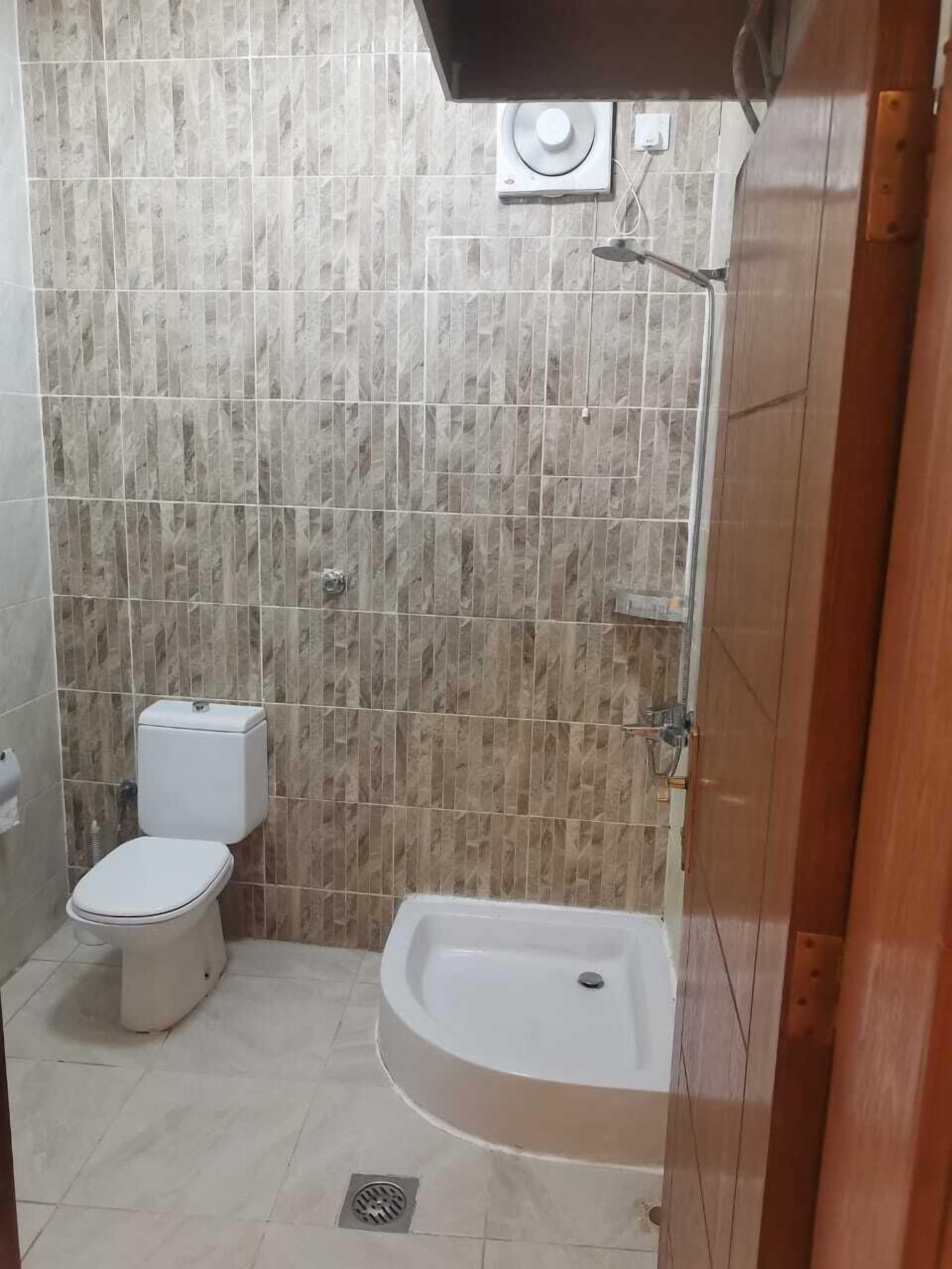 A bathroom with a toilet, a shower, and a bathtub.