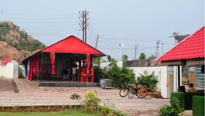 Un edificio con techo rojo y un espacio exterior cubierto con cortinas rojas.