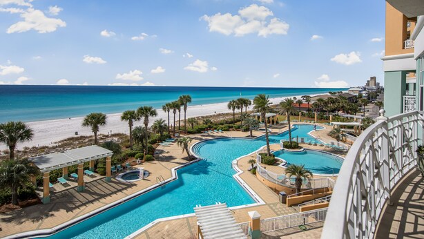 A resort pool area with multiple swimming pools, palm trees, and a beach view. - Luxury Gulf-Front Escape at En Soleil, Two King Suites & Stunning Views (Panama City)