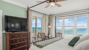 A bedroom with a bed, a TV, a dresser, and a balcony with a view of the ocean. - Luxury Gulf-Front Escape at En Soleil, Two King Suites & Stunning Views (Panama City)