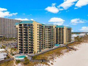 Ein Strandhotel mit mehreren Hochhäusern, einem Swimmingpool und einer Strandbucht.
