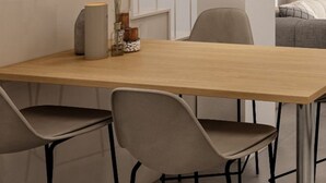 Ein moderner Essbereich mit einem Holztisch, zwei Stühlen und einer dekorativen Vase.
