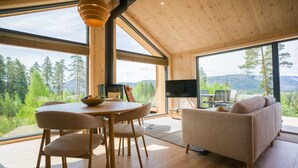 Ein modernes Interieur mit einem Holzespeisetisch, Stühlen, einer Couch und einem Fernseher.